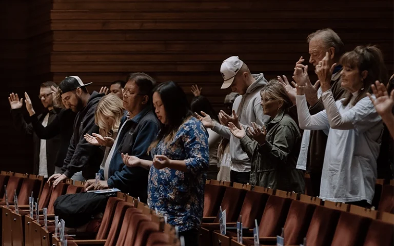 People praying and worshipping during the Good Friday service at New City Church in Naperville.