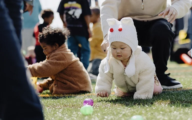 Toddlers crawling and collecting Easter eggs during the Easter Eggstravaganza at New City Church in Naperville.